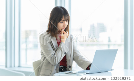 Woman/businesswoman thinking while using a computer 132919271