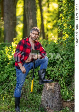 Hispanic man logging with axe in rubber boots. Lumberjack axe. Man with logging axe. Hardworking brutal man. Logging lumberjack man outdoor. Brutal lumberjack. Brutality and masculinity Hispanic man logging with axe in rubber boots. Lumberjack axe. Man with logging axe. Hardworking brutal man. Logging lumberjack man outdoor. Brutal lumberjack. Brutality and masculinity 132919433