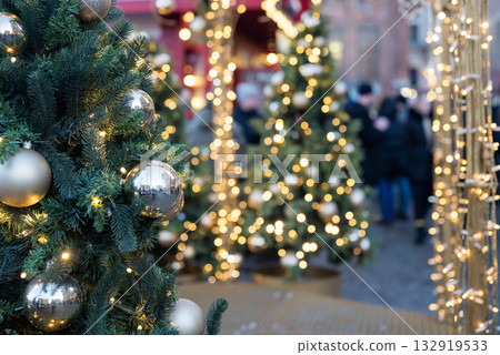 Christmas tree at a festive fair with a side and a garland, a blurry background Christmas tree at a festive fair with a side and a garland, a blurry background 132919533
