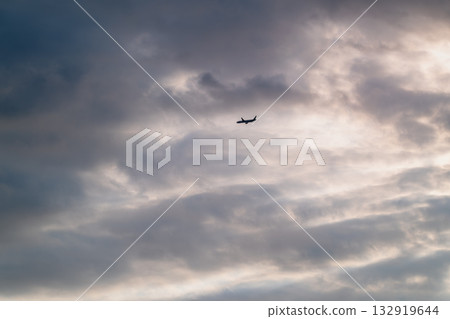 Airplane Flying Left under High Altitude Clouds in New Taipei City Taiwan. Airplane Flying Left under High Altitude Clouds in New Taipei City Taiwan. 132919644