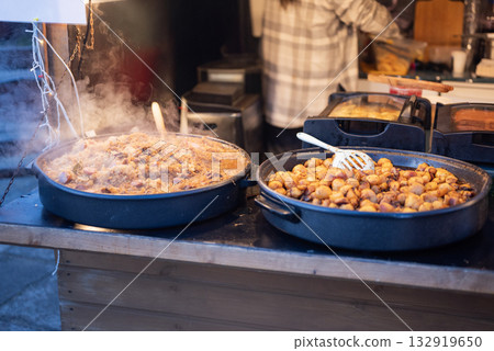 Prepared street food at a Christmas market, potatoes and cabbage, bigos, a national Polish food. Prepared street food at a Christmas market, potatoes and cabbage, bigos, a national Polish food. 132919650