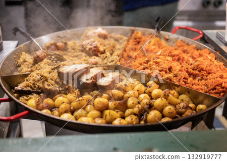 vendor fries meat and sausage and potato on the grill in the city center at the Christmas market in Gdansk Poland vendor fries meat and sausage and potato on the grill in the city center at the Christmas market in Gdansk Poland 132919777