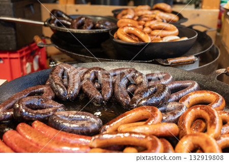 vendor fries meat and sausage on the grill in the city center at the Christmas market in Gdansk Poland vendor fries meat and sausage on the grill in the city center at the Christmas market in Gdansk Poland 132919808