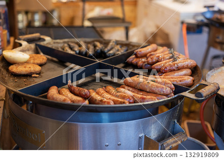 vendor fries meat and sausage on the grill in the city center at the Christmas market in Gdansk Poland 132919809