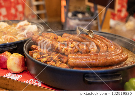 vendor fries meat and sausage and potato on the grill in the city center at the Christmas market in Gdansk Poland 132919820