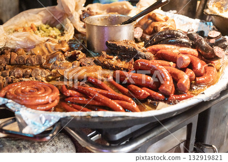 vendor fries meat and sausage and potato on the grill in the city center at the Christmas market in Gdansk Poland vendor fries meat and sausage and potato on the grill in the city center at the Christmas market in Gdansk Poland 132919821