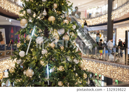 christmas tree in the mall for christmas with garland and decorations on blurred bokeh background christmas tree in the mall for christmas with garland and decorations on blurred bokeh background 132919822