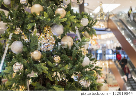 christmas tree in the mall for christmas with garland and decorations on blurred bokeh background 132919844