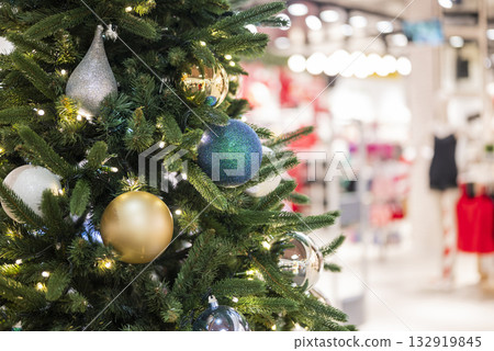 christmas tree in the mall for christmas with garland and decorations on blurred bokeh background 132919845