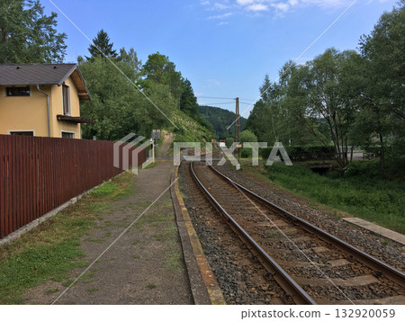 Curved railway track passing through quiet countryside station in Czech Republic. Simplicity, movement, and connection between rural life and nature harmony. Curved railway track passing through quiet countryside station in Czech Republic. Simplicity, movement, and connection between rural life and nature harmony. 132920059