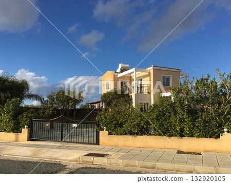 Cozy Mediterranean villa surrounded by greenery. Harmony, privacy, and bright suburban lifestyle in sunny Cyprus. Cozy Mediterranean villa surrounded by greenery. Harmony, privacy, and bright suburban lifestyle in sunny Cyprus. 132920105