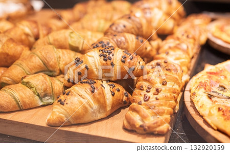 Delicious sweet pastries, croissants, on display in a cafe Delicious sweet pastries, croissants, on display in a cafe 132920159