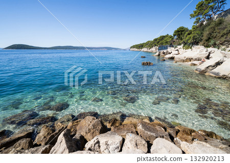 a beautiful beach with a view of the Adriatic Sea with rocks on the shore and pine trees in Split, Croatia a beautiful beach with a view of the Adriatic Sea with rocks on the shore and pine trees in Split, Croatia 132920213