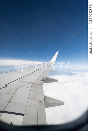 view from the window of an airplane in flight on clouds with the wing of a airplane view from the window of an airplane in flight on clouds with the wing of a airplane 132920278