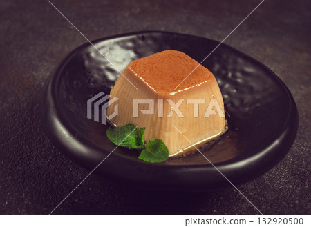 cream caramel pudding, with caramel sauce, dessert,breakfast, on a black plate, mint, no people, cream caramel pudding, with caramel sauce, dessert,breakfast, on a black plate, mint, no people, 132920500