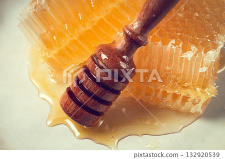 honeycomb, with a wooden spoon-spindle, on a plate, no people, 132920539