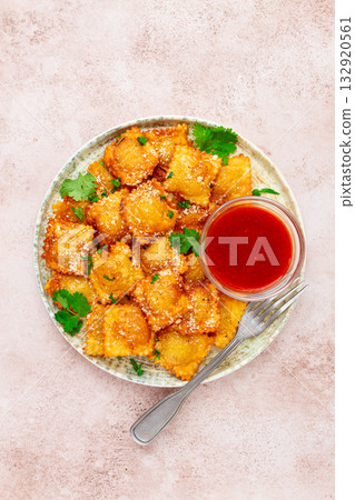 fried ravioli with parmesan cheese, served with red sauce and garnished with herbs, on a light background, no people, fried ravioli with parmesan cheese, served with red sauce and garnished with herbs, on a light background, no people, 132920561
