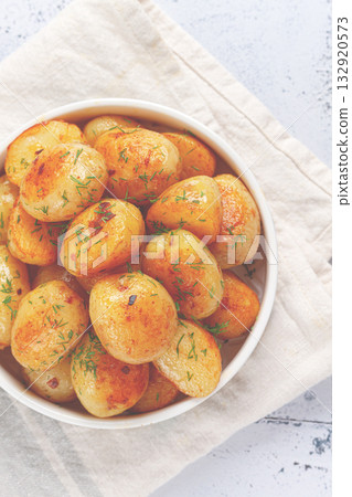 Baked new potatoes, with butter and dill, on a white plate, at home, no people, 132920573