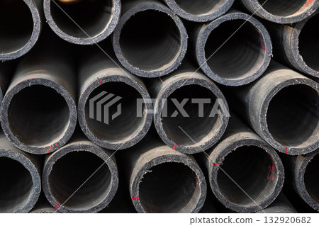 Close-up view of stacked black pipes showcasing industrial texture and design 132920682