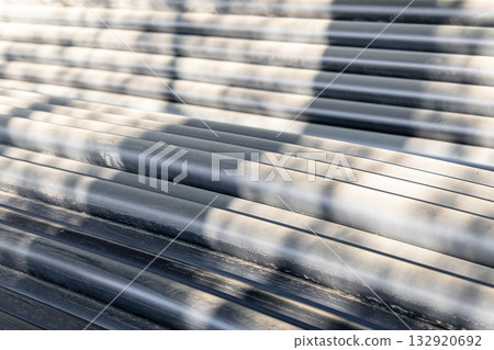 Textured surface of stack of plastic pipes with shadows creating abstract patterns and depth Textured surface of stack of plastic pipes with shadows creating abstract patterns and depth 132920692