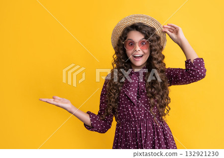 surprised happy child in straw hat and sunglasses with long brunette curly hair. copy space surprised happy child in straw hat and sunglasses with long brunette curly hair. copy space 132921230
