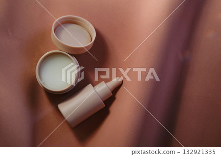 Face cream and serum on a soft beige background. 132921335