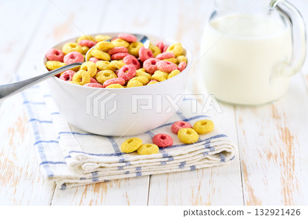 ceramic bowl of tasty corn rings and strawberry rings on a light kitchen table, selective focus. 132921426