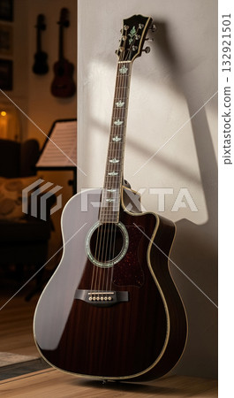 Detailed Close-Up of a Vintage Acoustic Guitar Leaning Against a Wall in a Cozy Room with Warm Ambient Light, Ready for a Practice Session 132921501