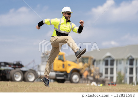 Worker jumping at heavy machines. Man engineer running to success. Builder man run fast to work. Engineer supervisor running outdoor. Supervisor jumping. Excited construction builder. Great job 132921598