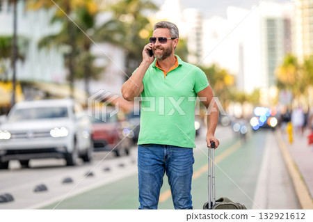Tourist booking vacation trip. Traveler suitcase for summer trip. Man booking summer trip. Hispanic tourist traveler book online. Tourist with travel bag. Traveler using phone. Voyage lifestyle Tourist booking vacation trip. Traveler suitcase for summer trip. Man booking summer trip. Hispanic tourist traveler book online. Tourist with travel bag. Traveler using phone. Voyage lifestyle 132921612