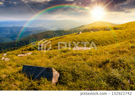 green alpine meadows in mountains in summer at sunset. stones on grassy hills in evening light. popular travel destination for photo. storytelling image under the rainbow. beautiful place 132921742