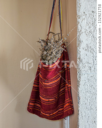A red bag in the corner of the room with dry lavender 132921758
