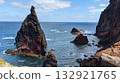 Jagged volcanic sea stacks rising from deep blue ocean 132921765