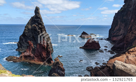 Jagged volcanic sea stacks rising from deep blue ocean Jagged volcanic sea stacks rising from deep blue ocean 132921765
