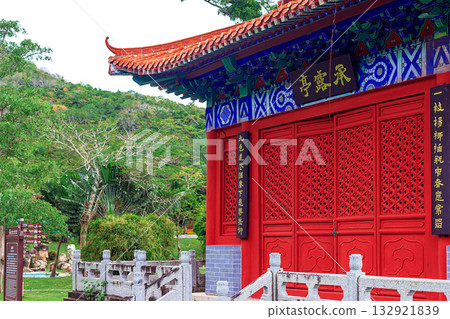 A traditional Chinese building with red walls, carved doors, and a curved roof. A traditional Chinese building with red walls, carved doors, and a curved roof. 132921839