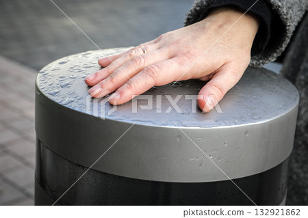 Hand Touching Wet Metal Surface Outdoors Hand Touching Wet Metal Surface Outdoors 132921862