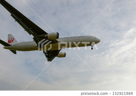 Cloudy sky and a landing JAL plane 132921989