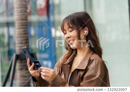 Happy young woman person, enjoying summer outdoor travel lifestyle tourist holiday, uses smartphone and credit card for modern shopping, people connecting digitally payment convenience. Happy young woman person, enjoying summer outdoor travel lifestyle tourist holiday, uses smartphone and credit card for modern shopping, people connecting digitally payment convenience. 132922007