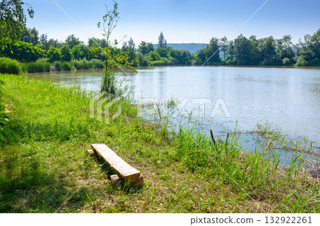 lake near forest. beautiful view of a nature landscape in summer. calm sunny morning in carpathian mountains. country scenery under clear blue sky. vacations in remote place lake near forest. beautiful view of a nature landscape in summer. calm sunny morning in carpathian mountains. country scenery under clear blue sky. vacations in remote place 132922261