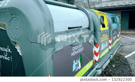 Color-coded municipal trash and recycling bins used for household waste sorting in France, showing public recycling system for plastic, metal, paper, glass and general waste management 132922300