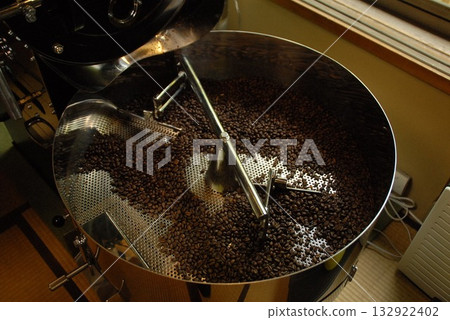 A scene of fragrant coffee beans being roasted in a large roaster A scene of fragrant coffee beans being roasted in a large roaster 132922402