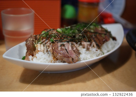 A plate of juicy steak rice and a drink reflected in a glass A plate of juicy steak rice and a drink reflected in a glass 132922436