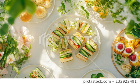Elegant summer picnic spread with fresh sandwiches and sweet desserts Elegant summer picnic spread with fresh sandwiches and sweet desserts 132922491