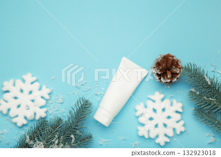 Winter skin care concept. Cosmetic moisturizer cream and snowflakes on blue background. Space for text 132923018
