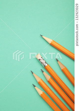 Graphite pencil with eraser on mint background. School stationery. Vertical photo Graphite pencil with eraser on mint background. School stationery. Vertical photo 132923029