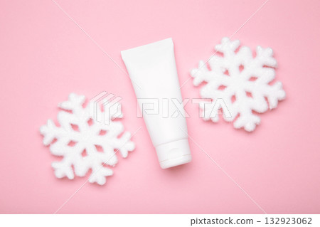 Winter skin care concept. Cosmetic moisturizer cream and snowflakes on pink background. 132923062