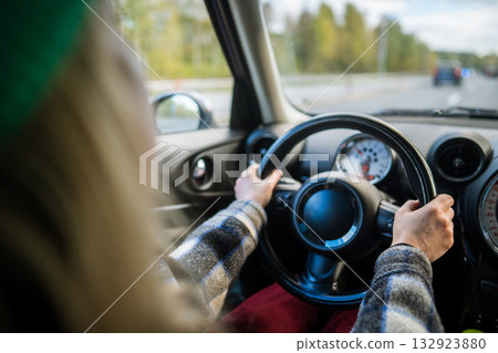 POV woman driving car in traffic on city road, hands on steering wheel. Female on multi lane highway POV woman driving car in traffic on city road, hands on steering wheel. Female on multi lane highway 132923880