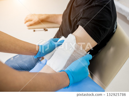 Nurse dressing wound for patient's hand with burn injury Nurse dressing wound for patient's hand with burn injury 132925786