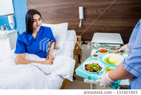 Nurse in medical coat is holding a tray with breakfast  132925803