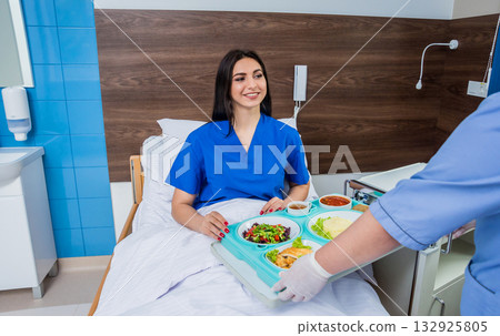 Nurse in medical coat is holding a tray with breakfast  132925805